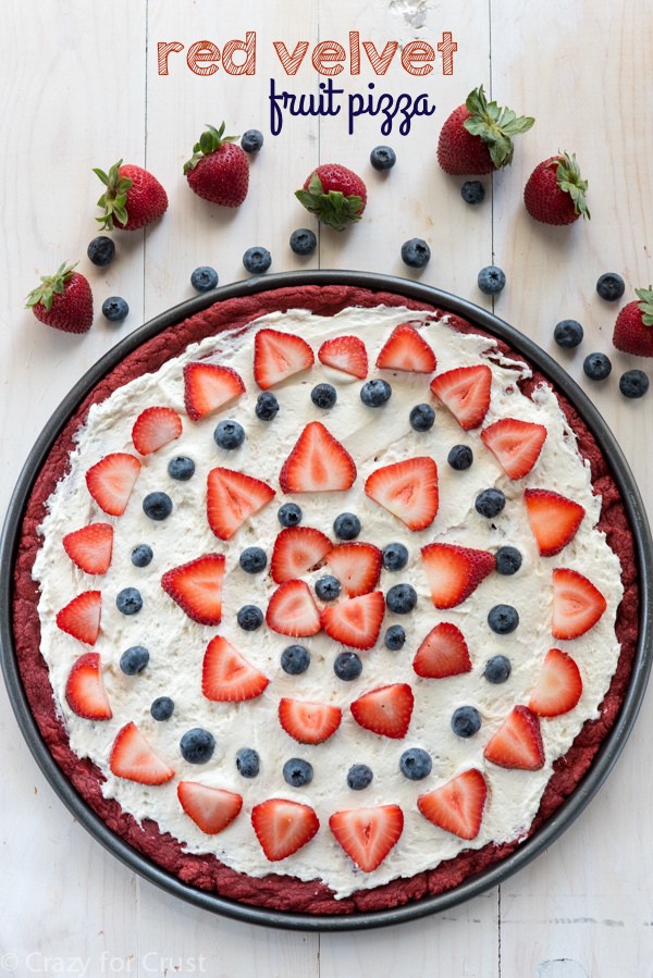 Red Velvet Fruit Pizza - a giant pizza cookie made from cake mix and topped with cream cheese whipped cream and fruit. It's the perfect potluck recipe!