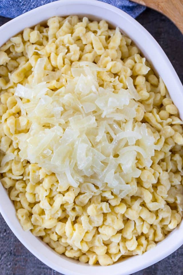 overhead shot of knoepfle in a casserole dish topped with onions