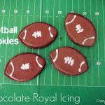 chocolate sugar cookies with royal icing on top on green football field paper