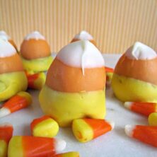 brownie bites dipped in chocolate to look like candy corn on marble slab with candy corn around