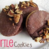 turtle cookies chocolate sandwich cookies with caramel inside and pecans on top on white plate with words
