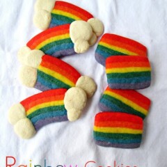 sugar cookies dyed rainbow colors with white clouds at ends on white linen