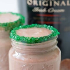 baileys pudding shot in shot glass with green sugar on the rim