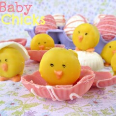 baby chick mini oreo dipped in yellow chocolate sitting on half a pink chocolate easter egg