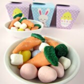 cadbury eggs marshmallows and bugles dipped in chocolate to look like carrots in white dish