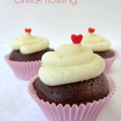 Brownie Bites with white frosting on top and a heart sprinkle on white background