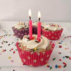 funfetti cupcakes with rainbow sprinkles, front cake has two birthday pink candles