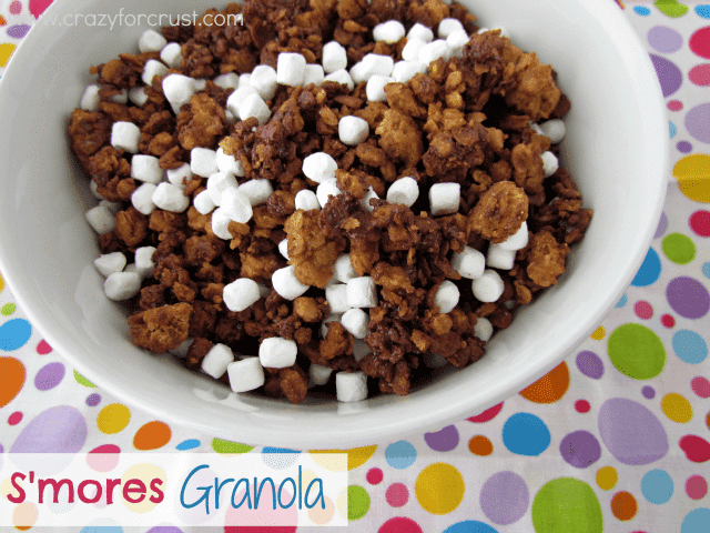 smores granola with mini marshmallows in white bowl on colorful linen and words on photo