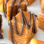 orange butterfinger fudge with chocolate sauce dripped over the top.