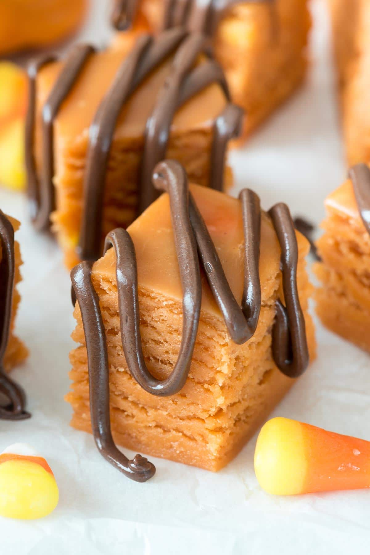 orange butterfinger fudge with chocolate sauce dripped over the top.