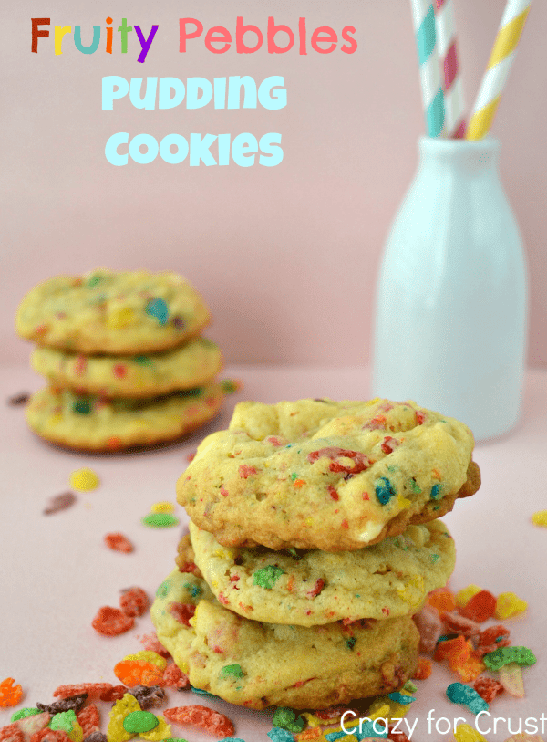 Stack of Fruity Pebbles Pudding Cookies on pink background with fruity pebbles scattered around
