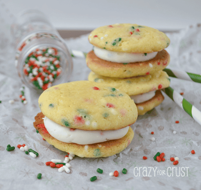 funfetti cookie sandwiches with cream center and christmas sprinkles on parchment paper
