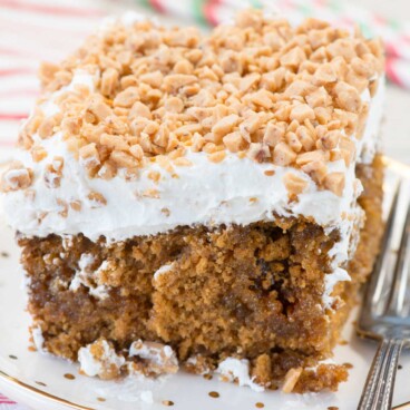 A Gingerbread Poke Cake is the perfect Christmas cake recipe! Gingerbread cake is filled with butterscotch and gingersnaps and topped with whipped cream and toffee bits!
