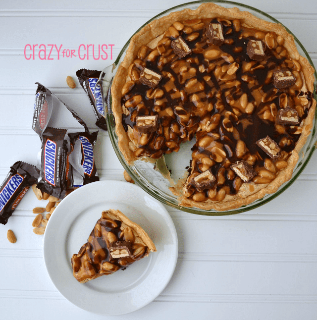 overhead shot of snickers pie and slice on white plate