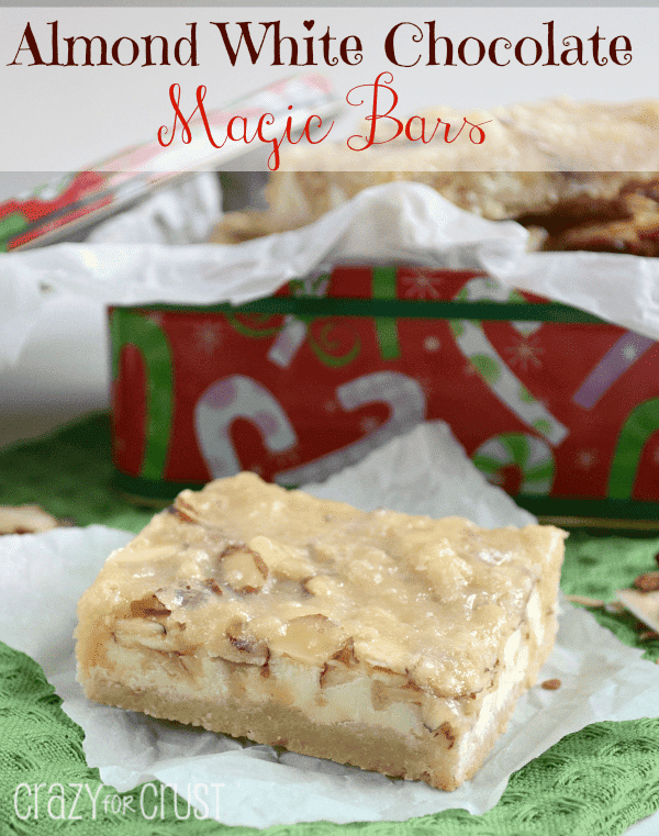 almond white chocolate magic bars on parchment paper with christmas container in back and words on photo
