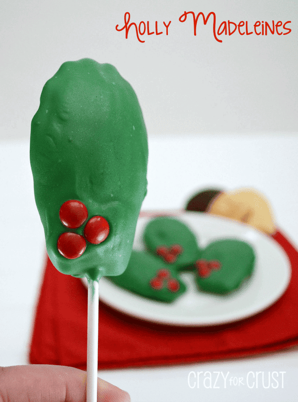 holly madeleines - cake dipped in green chocolate to look like holly on a stick