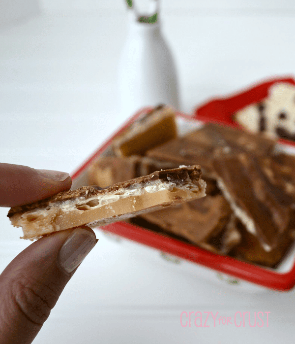 Peanut Butter Chocolate Toffee Bark held by two fingers with title