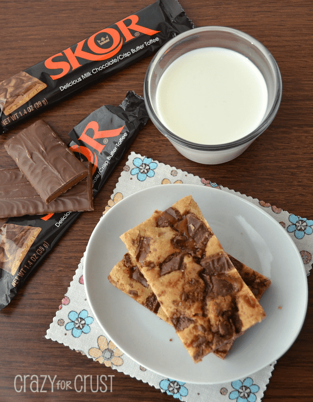 An overhead view of toffee blondies on a table next to skor candy bars.