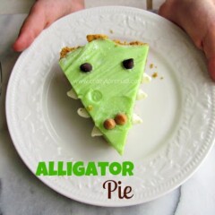 child holding white plate with slice of pie