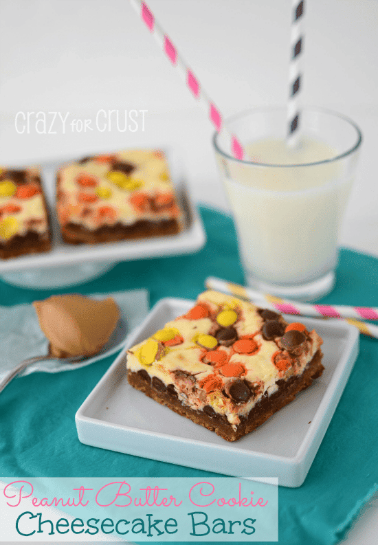 Peanut Butter Cookie Cheesecake Bars by www.www.crazyforcrust.com | A peanut butter cookie base topped with chocolate chips, cheesecake, and Reese's Pieces. One of the best cheesecake bars yet! #Reeses #cheesecake #cookie cheesecake slice on white square plate