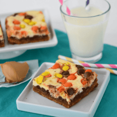 Peanut butter cookie cheesecake bars on a white plate with a forkful of peanut butter next