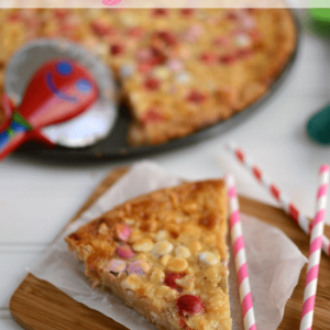 White Chocolate Macadamia Magic Pizza slice on parchment and cutting board