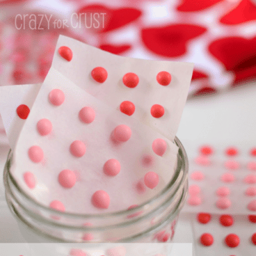 pink and red candy buttons on white background and in jar