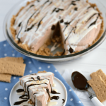 Skinny Frozen S'mores Pie with slice on white plate and pie with slice missing