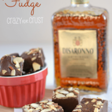 amaretto fudge on parchment paper on cutting board with bottle behind