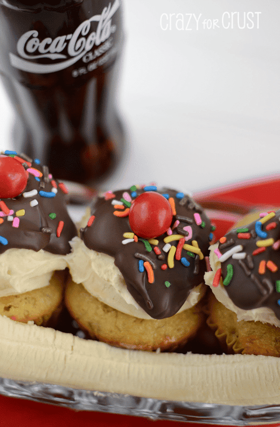 banana split cupcakes in ice cream dish decorated like a sundae with a banana 