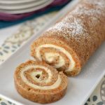 carrot cake roll sliced on white platter