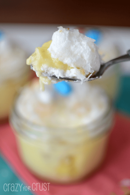 coconut cream pies in jars with jelly beans on top on spoon