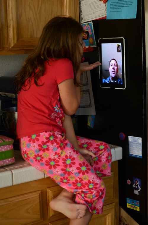 Daughter and dad using KICMount on fridge to video chat with each other