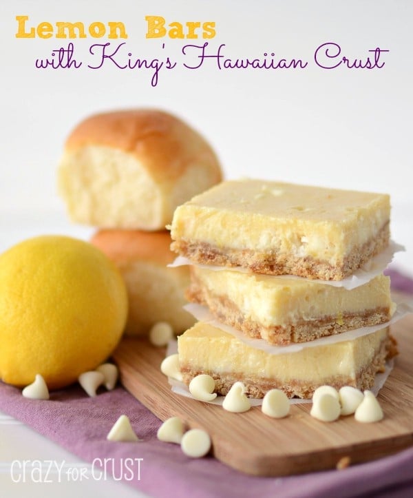 lemon bars in a stack on cutting board with rolls behind and lemon and words on photo