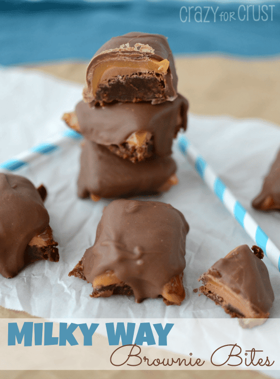 Milky Way Brownie Bites on white parchment paper with blue straws and recipe title on the bottom of the image