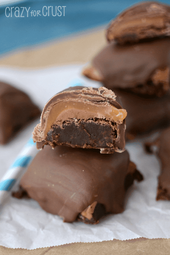 Two Milky Way brownie bites with one cut in half to show the middle filling
