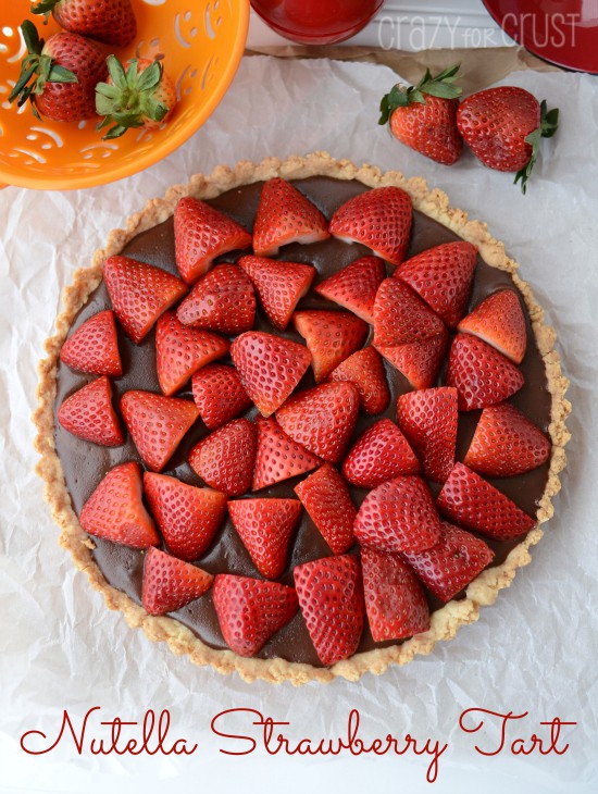 Overhead shot of Nutella Strawberry Tart on white parchment paper with recipe title at bottom of image