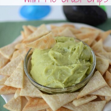 Sweet Guacamole Dip in a glass bowl with Pie Crust Tortilla Chips around it on a serving plate with recipe title on top of image