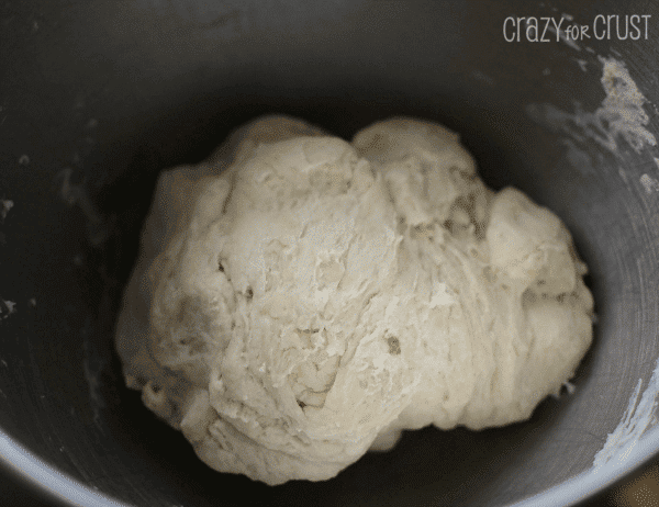 Overhead shot of dinner roll dough in stainless steel bowl