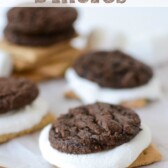 brownie cookie sandwiched with melted marshmallow and graham cracker on parchment paper