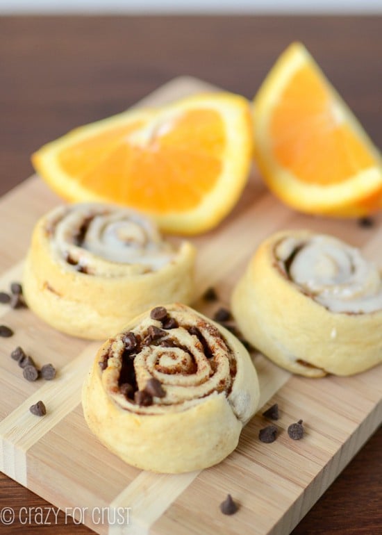 orange sweet rolls with and without icing on cutting board 