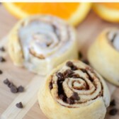 orange sweet rolls with and without icing on cutting board with words on photo