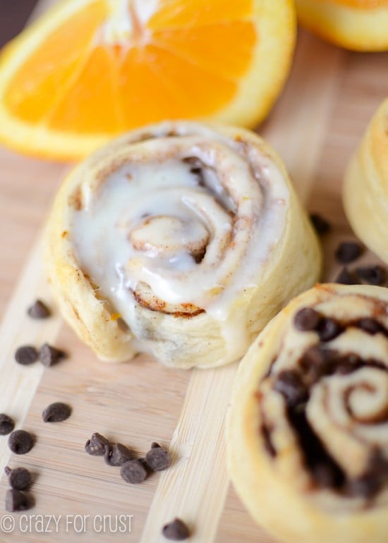 orange sweet rolls with and without icing on cutting board 
