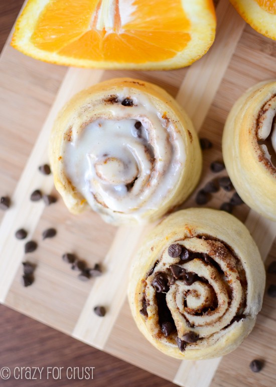 orange sweet rolls with and without icing on cutting board 