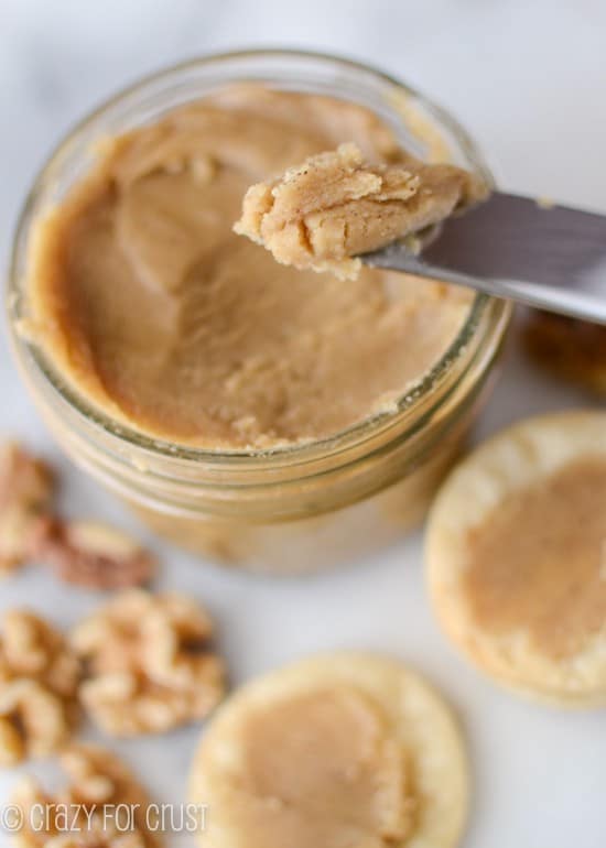 maple walnut butter in jar with walnuts and pie crust chips and knife