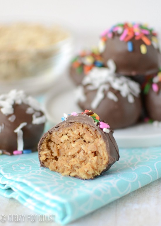 peanut butter oatmeal truffles coated in chocolate on white plate and teal napkin with one truffle cut in half 