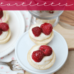 tarts on white platter with cream and raspberries