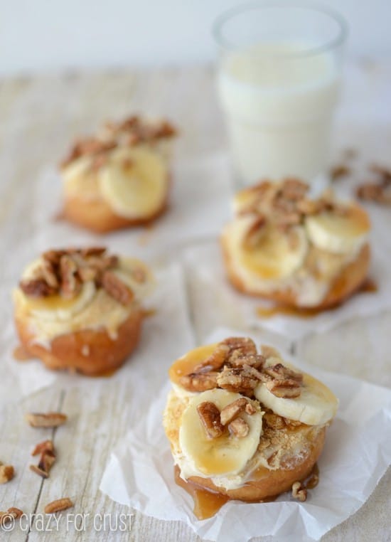 fried doughnut on parchment paper topped with bananas nuts and caramel