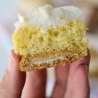 hand holding sliced banana cupcake that has an oreo bottom and frosting