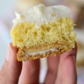 hand holding sliced banana cupcake that has an oreo bottom and frosting